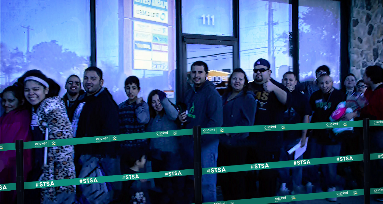 People waiting in line guided by a stanchion